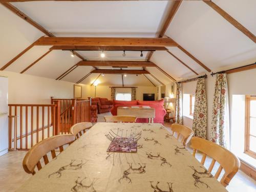 a dining room with a long table and chairs at Hayloft Cottage in Little Glenham