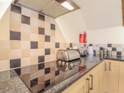 a kitchen with a sink and a counter top at Hayloft Cottage in Little Glenham