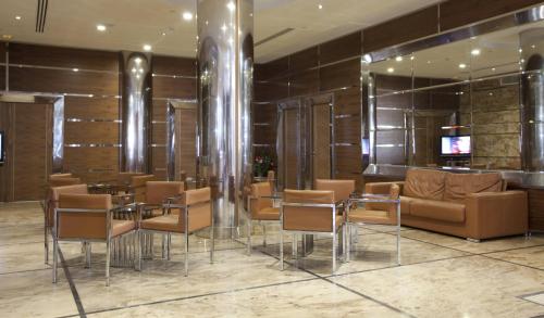 a restaurant with chairs and tables and a bar at Gran Hotel Corona Sol in Salamanca