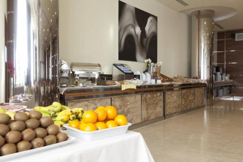 a buffet with oranges and other fruits on a table at Gran Hotel Corona Sol in Salamanca