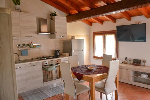 a kitchen with a table and chairs in a room at Il Paiolo Magico in Valeggio sul Mincio