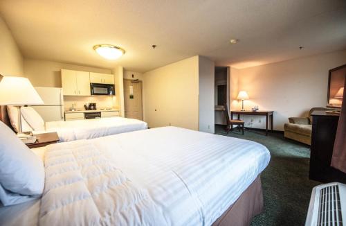 Un pat sau paturi într-o cameră la Greystone Inn & Suites