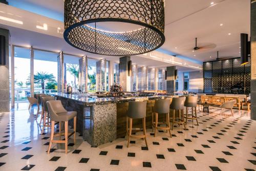a bar in a restaurant with a large chandelier at Dreams Karibana Cartagena Golf & Spa Resort in Cartagena de Indias