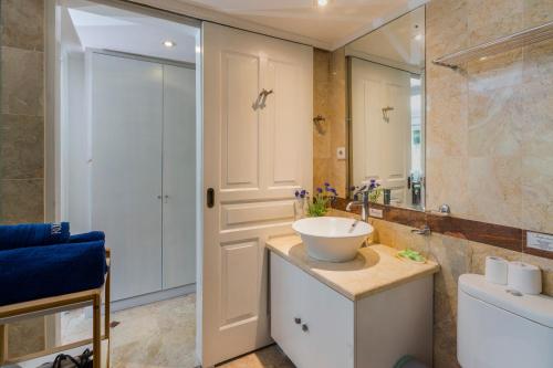 a bathroom with a sink and a mirror at Cozy Bali Apartment in Seminyak