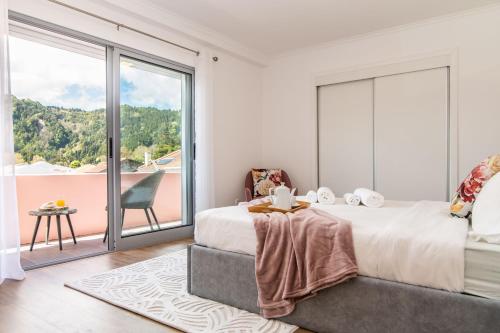 a bedroom with a large bed and a large window at Furnas Apartment in Furnas