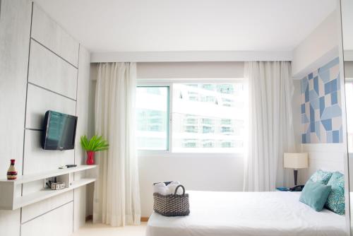 a white bedroom with a bed and a window at BSB STAY Premium Flats Particulares - Saint Moritz in Brasilia