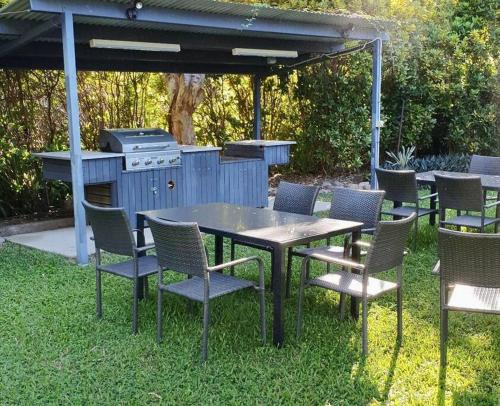 a table and chairs and a grill in a yard at Magnetic Diamond - Gorgeous Holiday Chalet in Nelly Bay