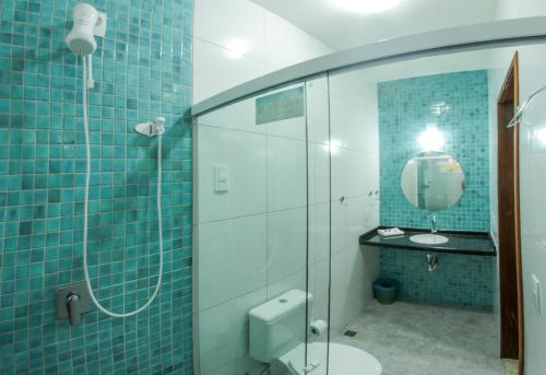 La salle de bains est pourvue de carrelage bleu, de toilettes et d'un miroir. dans l'établissement Recanto da sereia, à Jericoacoara