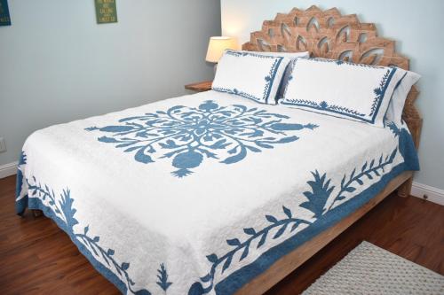 a bed with blue and white sheets and pillows at Sealodge G9 in Princeville