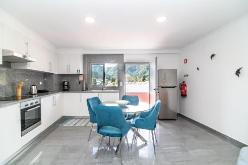 a kitchen with a table and chairs and a refrigerator at Furnas Apartment in Furnas
