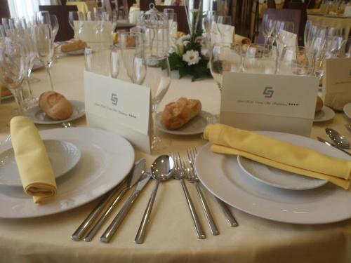 a table with plates and forks and spoons and silverware at Gran Hotel Corona Sol in Salamanca