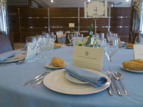 a table with a blue table cloth with plates and silverware at Gran Hotel Corona Sol in Salamanca