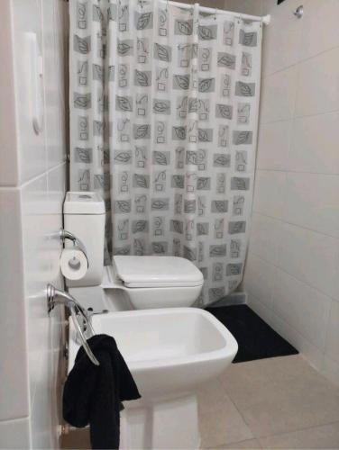 a bathroom with a toilet and a shower curtain at Alquiler temporario Rosario in Rosario