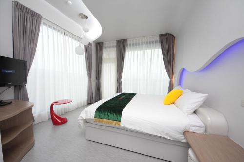 a bedroom with a bed with a blue headboard and a tv at Follow Me designed B&B in Dongshan
