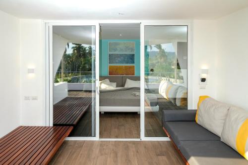a living room with a couch and a living room with glass doors at Puerto Plaza Las Terrenas in Las Terrenas