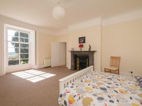 a bedroom with a bed and a fireplace at The Patio Flat in Bodmin