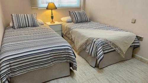 dos camas sentadas una al lado de la otra en un dormitorio en Elegante piso en Puerto de la Cruz, en Puerto de la Cruz
