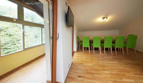 einen Konferenzraum mit grünen Stühlen und einem Flachbild-TV in der Unterkunft Holiday Lodge Central in Saalbach-Hinterglemm