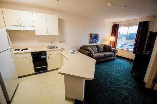 a kitchen and living room with a couch and a table at Greystone Inn & Suites in Vance