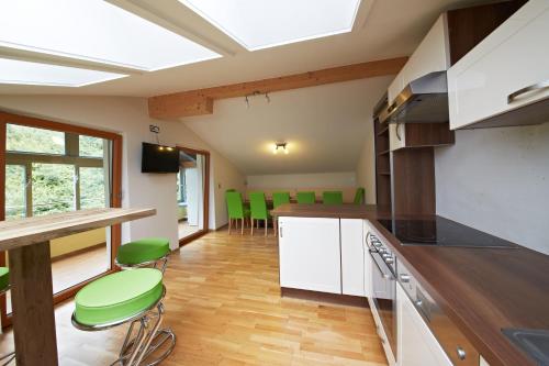eine Küche mit grünen Stühlen und einer Arbeitsplatte in der Unterkunft Holiday Lodge Central in Saalbach-Hinterglemm