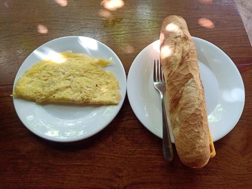 a plate with a piece of bread and a knife and fork at Tribal Village Homestay & Trekking in Banlung
