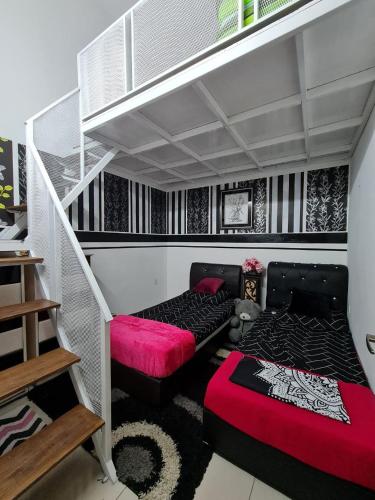 a room with two beds and a staircase at Embon Homestay in Padang Serai