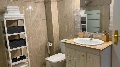 a bathroom with a sink and a toilet and a mirror at Elegante piso en Puerto de la Cruz in Puerto de la Cruz