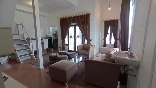 - un salon avec un canapé et un lavabo dans l'établissement DIENG GHUZY HOUSE syariah family room, à Wonosobo