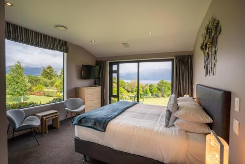 a bedroom with a large bed and a large window at High Leys Lodge in Te Anau