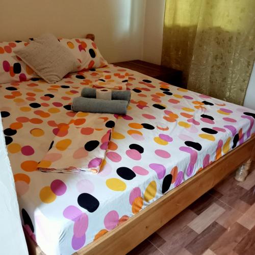 a bed with a polka dot bedspread and pillows at JANHOUR PLACE in San Vicente