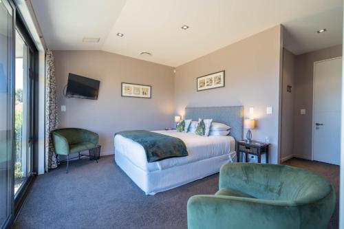 a hotel room with a bed and a chair at High Leys Lodge in Te Anau