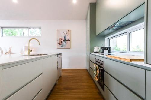 a kitchen with white cabinets and a sink at Central Hideaway-close to everything in Warrnambool