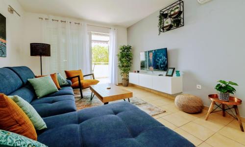 a living room with a blue couch and a table at Apartment Novalja on the moon in Novalja