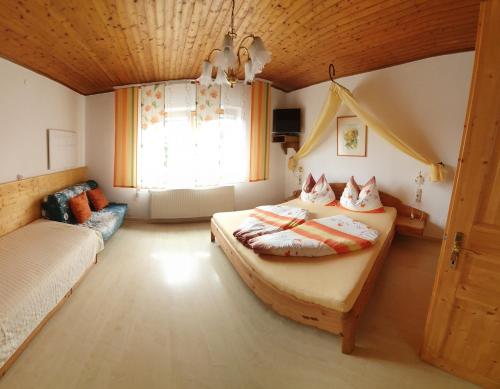a bedroom with two beds and a window at Weingut Bohrn Himmelbett in Herrnbaumgarten