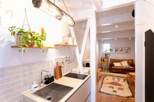 a kitchen with a sink and a living room at Bonjour Maison -Self check-in in Fukuoka