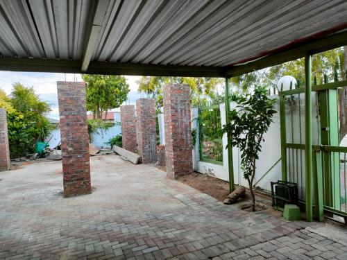 an empty patio with brick pillars and windows at Kea bed and breakfast in Mogwase