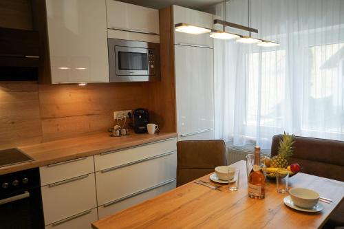 a kitchen with a wooden table and a kitchen counters at Ferienwohnungen Jodlbauerhof in Weyregg