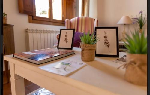 a table with two framed pictures and a laptop on it at Hotel Rural en Las Cascadas de Tobera in Tobera
