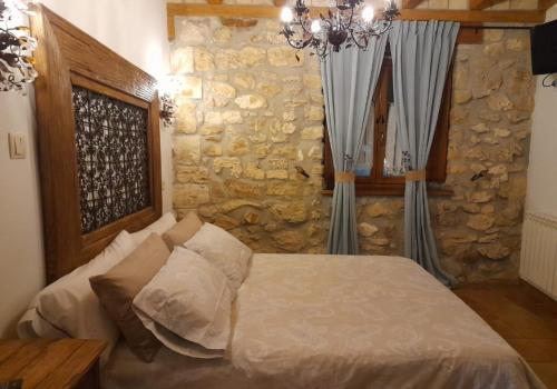 a bedroom with a bed and a stone wall at Hotel Rural en Las Cascadas de Tobera in Tobera