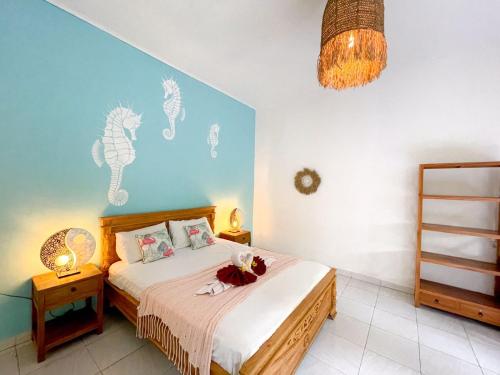 1 dormitorio con cama y pared azul en Enak Bungalow, en Amed