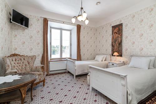 a bedroom with two beds and a couch and a table at Padise Manor in Padise