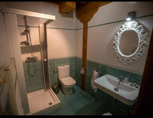 a bathroom with a sink and a toilet and a mirror at Hotel Rural Cascadas de Tobera in Tobera