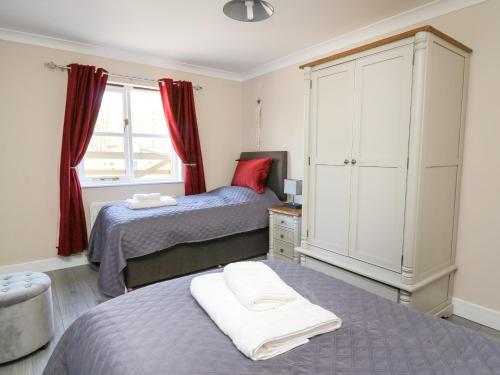 a bedroom with two beds and a large window at Glyn Cottage in Llanon