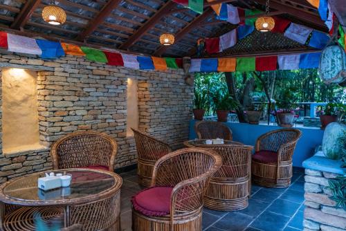 a patio with wicker chairs and tables and flags at Hotel Silver Oaks Inn in Pokhara