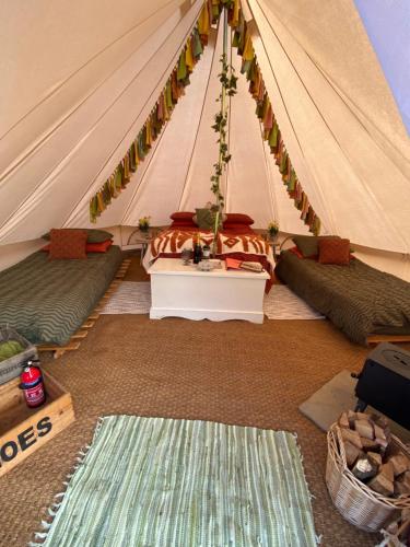 a tent with two beds and a table in it at Glen Farm Glamping in Cromer