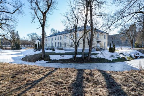 a large white house with trees in the snow at Padise Manor in Padise