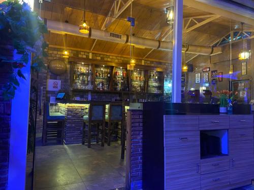 a bar with bar stools and bottles of alcohol at HOTEL HILL VIEW in Dehradun