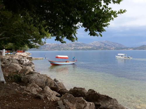 dos barcos en un cuerpo de agua con montañas en Choo Choo Pansiyon, en Egirdir