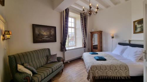 een woonkamer met een bed en een bank bij Landgoed Kasteel Terborgh in Schinnen