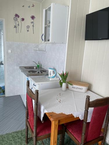 cocina con mesa con sillas y fregadero en Niebieska Tawerna, en Węgorzewo